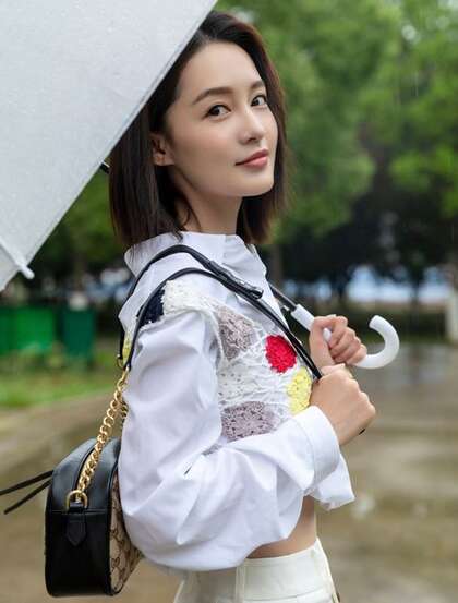 李沁手拿雨伞雨天出街，白衣短裙气质清新