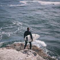 海边抱着冲浪板的欧美年轻人唯美励志运动图片