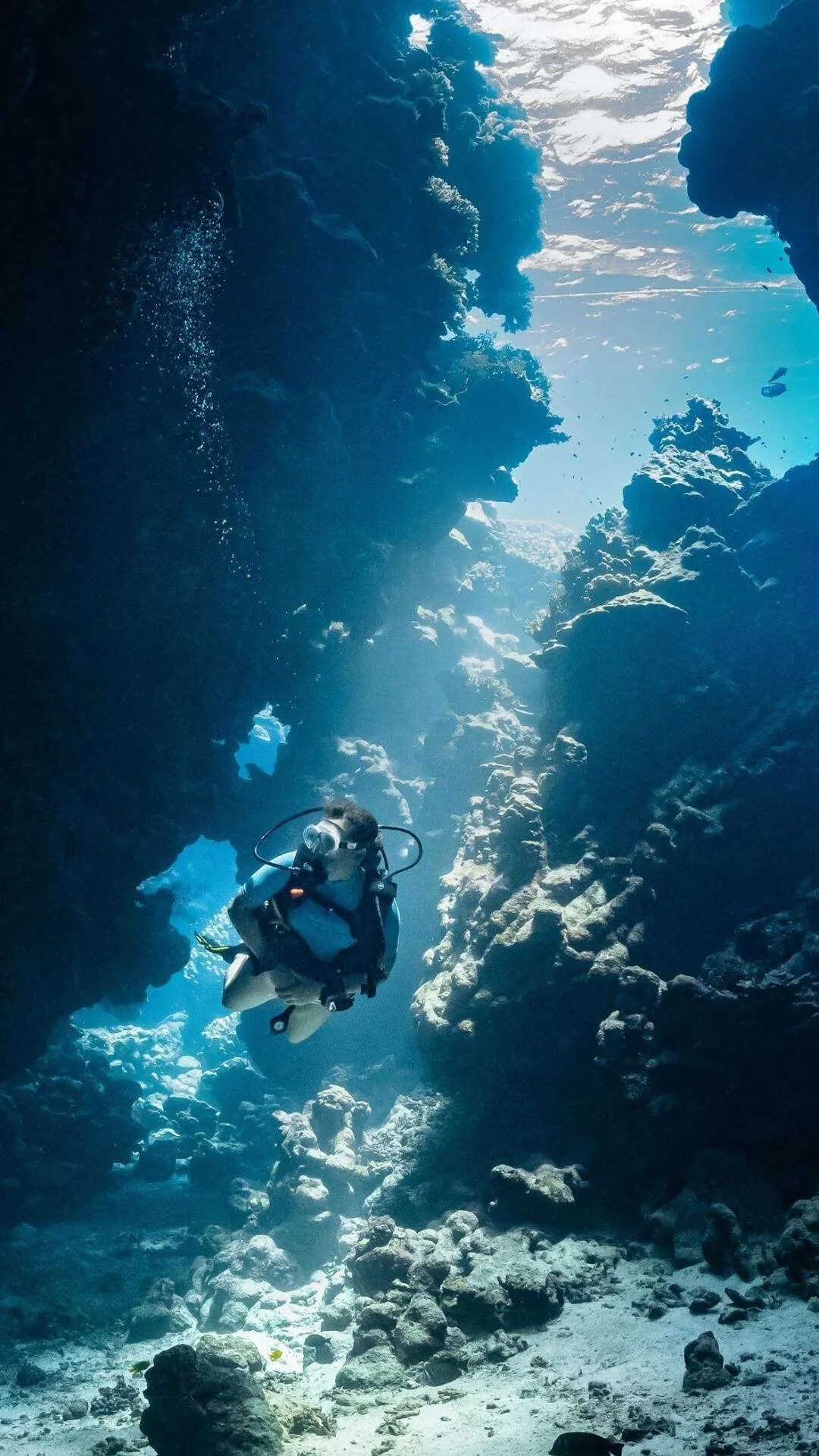 海底，一个潜泳的欧美女性，透过湖面的光，唯美水下摄影手机壁纸