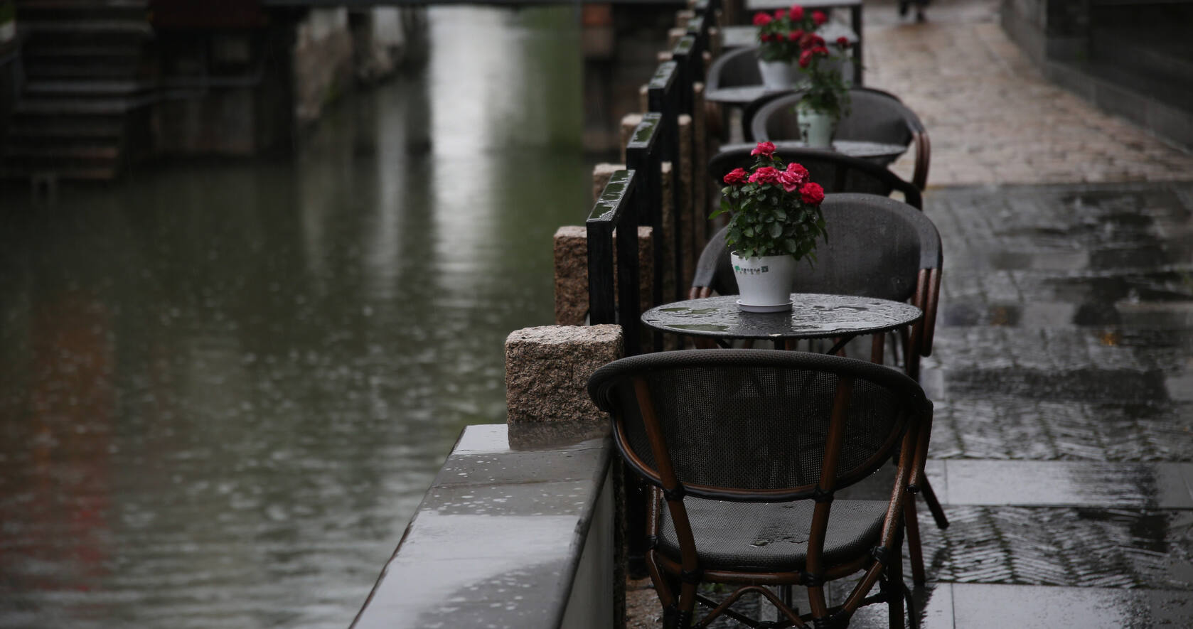 下雨的古镇，河边的古镇石头围栏边的餐厅座椅唯美摄影电脑壁纸第1张图片