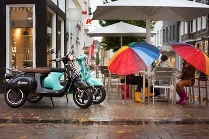 下雨的城市街头，在餐厅门前躲雨的路人场景桌面壁纸