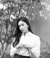 围墙下的一棵小树前，刘令姿白衫黑裙气质黑白写真美照