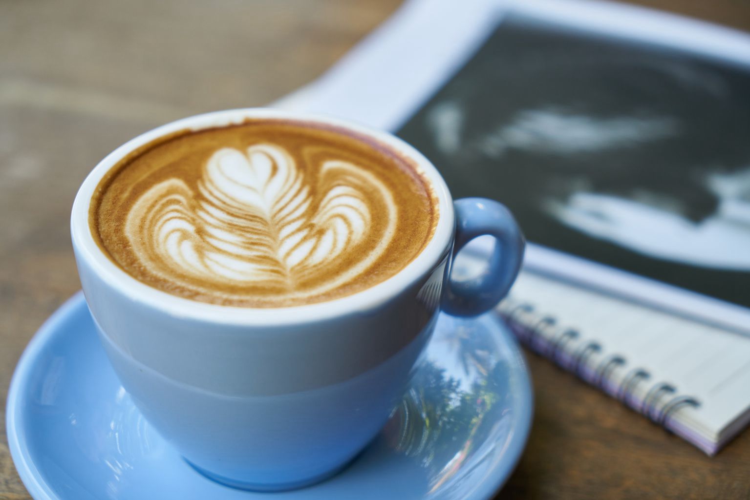 香浓的咖啡，女人的手 日记本 桌子 杯子 唯美拉花咖啡图片图片