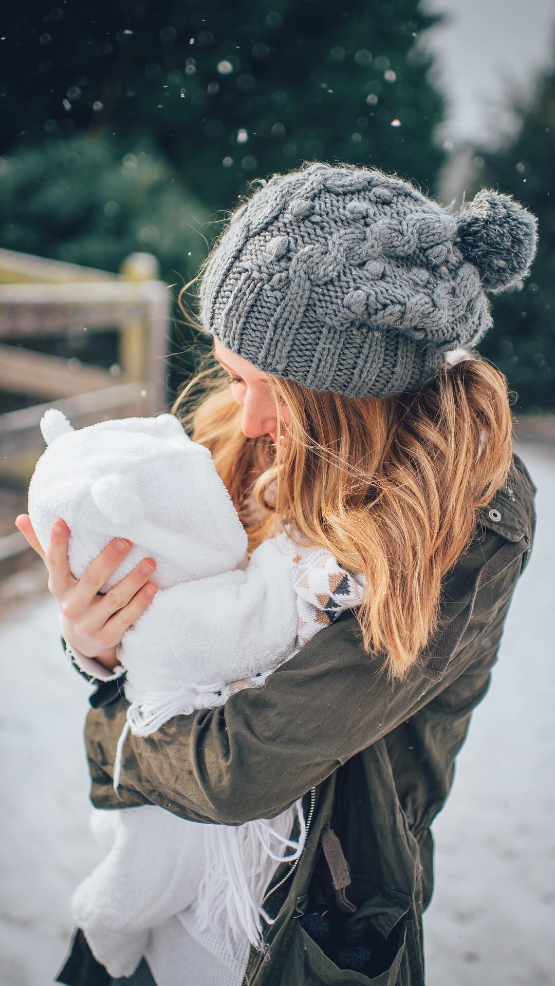 下雪天，一个穿着严实，抱着婴孩的欧美母子手机壁纸图片
