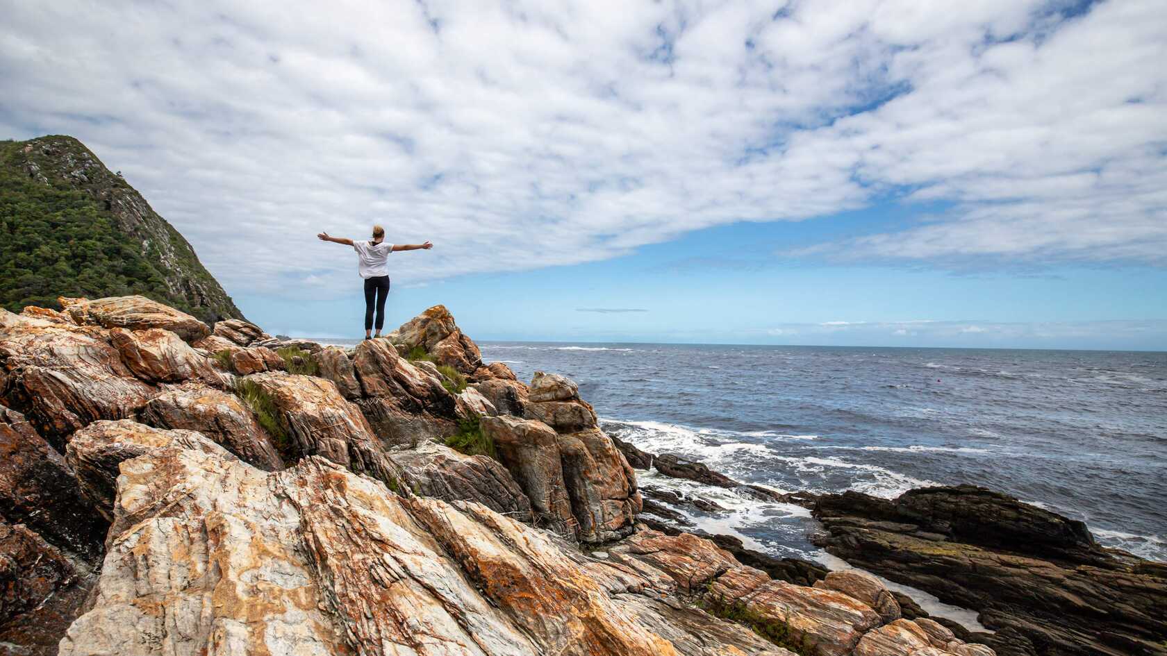 海边 礁石区 站在石头山的欧美女子背影 自由自在海边风景壁纸图片