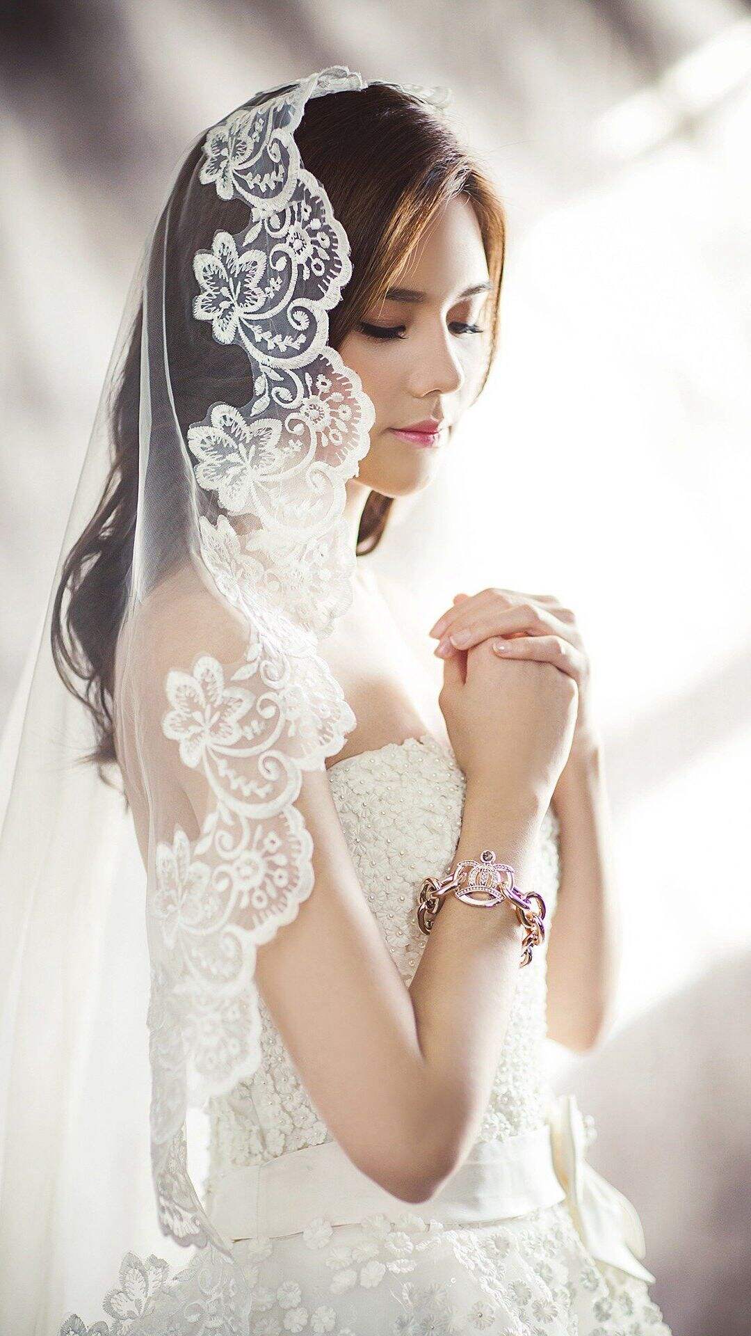 穿婚纱的欧美漂亮新娘子双手抱拳祈祷唯美高清手机壁纸图片