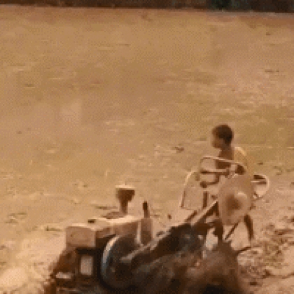 小朋友驾驶着耕地拖拉机在水田里玩的超嗨皮搞笑gif图片