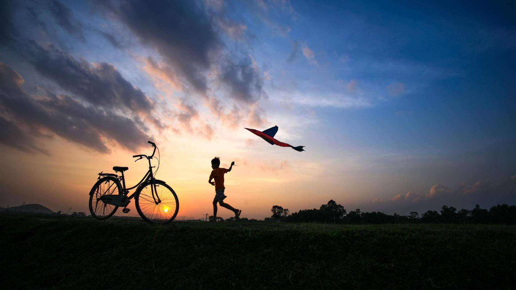 日落，黄昏，一个放风筝的小男孩，自行车唯美意境壁纸图片