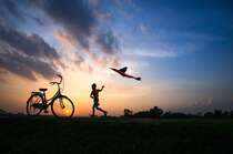 日落，黄昏，一个放风筝的小男孩，自行车唯美意境壁纸图片