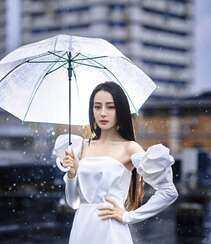 迪丽热巴纯白连衣裙穿着，手拿雨伞，雨中漫步优雅迷人青春写真图片
