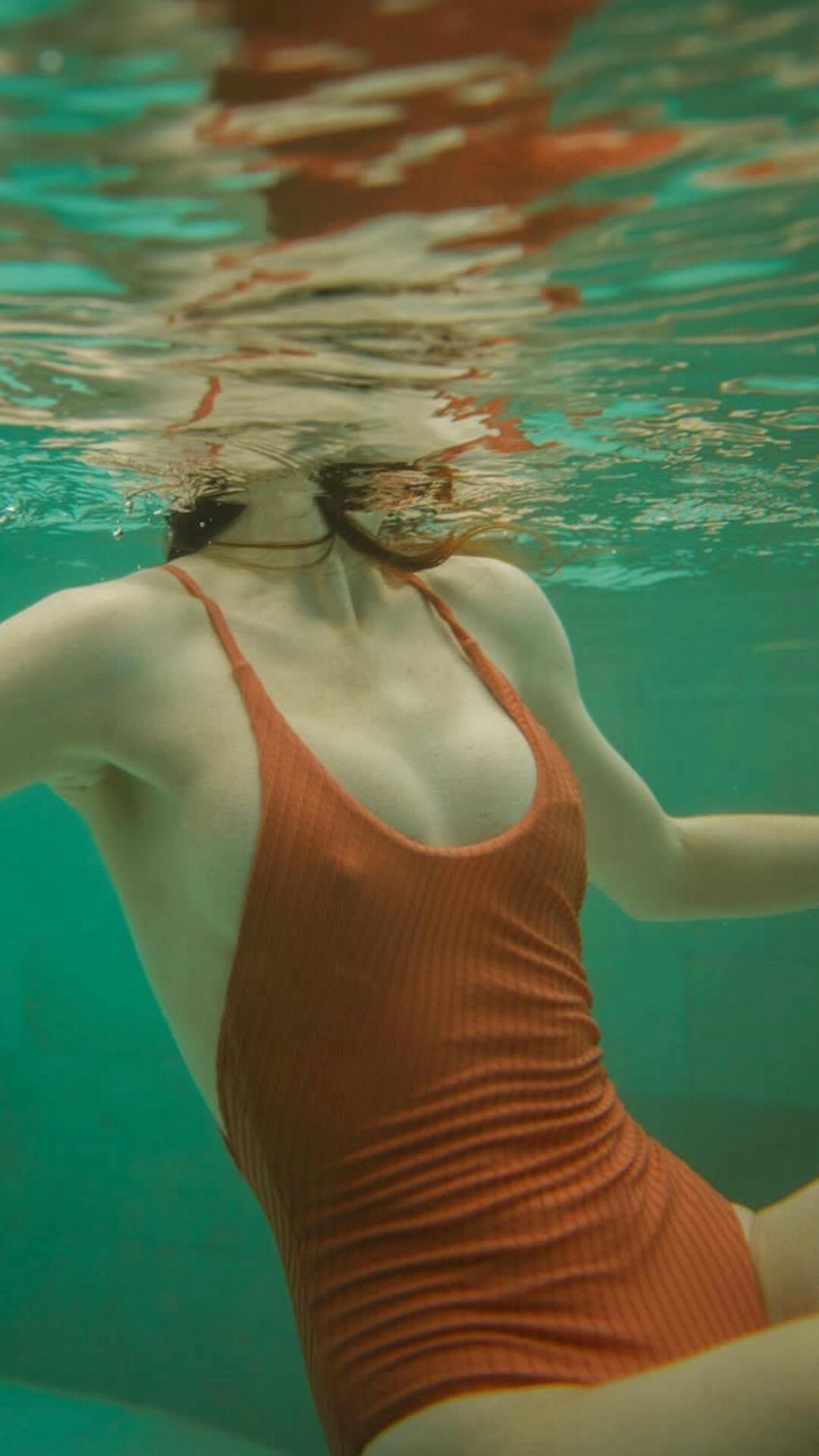欧美女生水下摄影美图，红色吊带连体比基尼的欧美女生水中写真手机壁纸