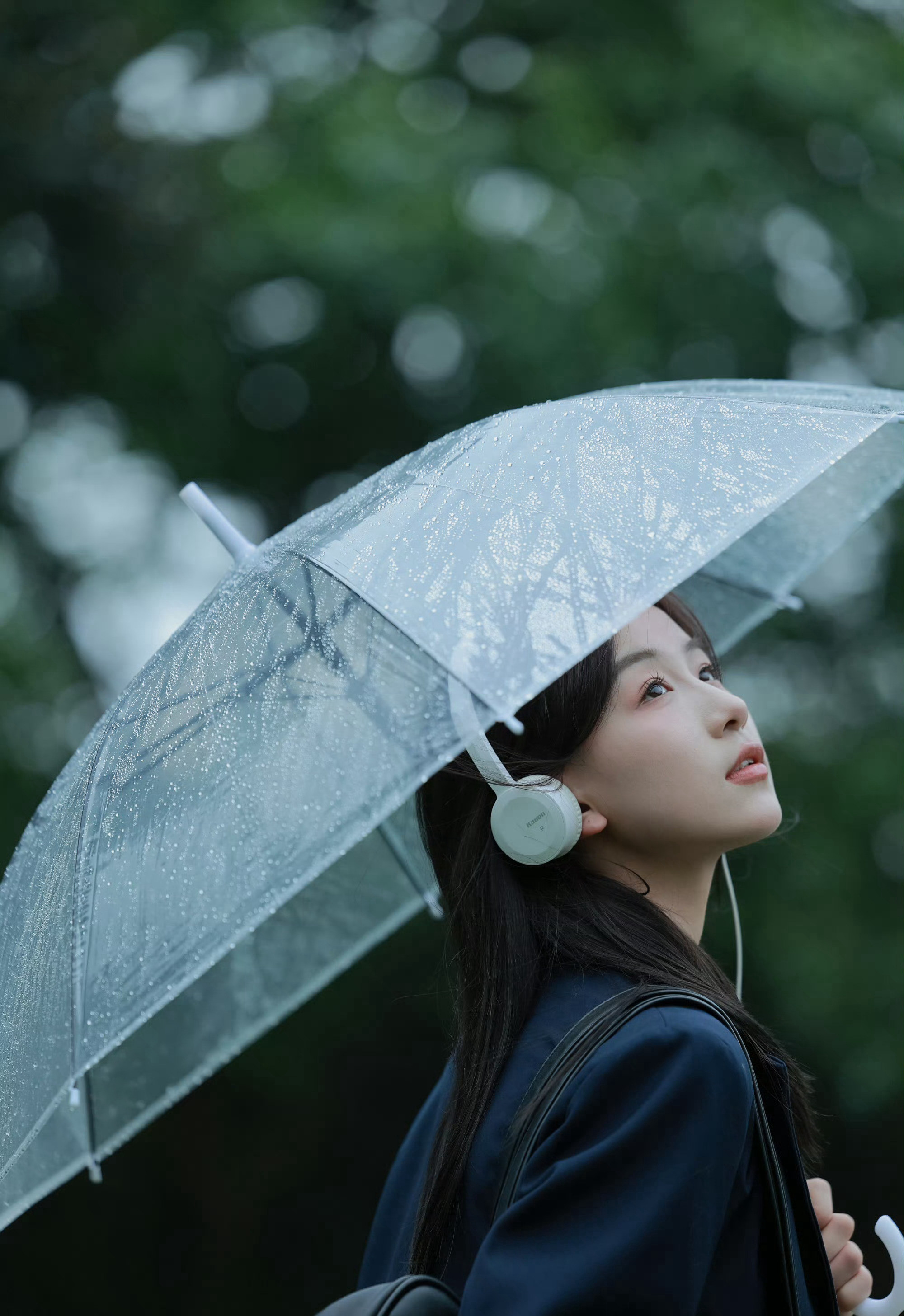 轻风细雨，享受一个人的清新和音乐，撑伞行走在阴雨中的女孩漫步绿荫树下摄影美图图片