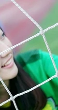 绿茵场上玩足球的 绿衣牛仔短裤妹子写真照片