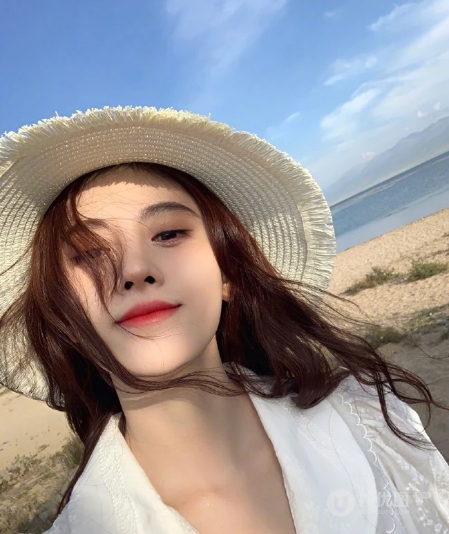 女生鞠婧祎一袭白裙装扮海边沙滩游玩写真照片