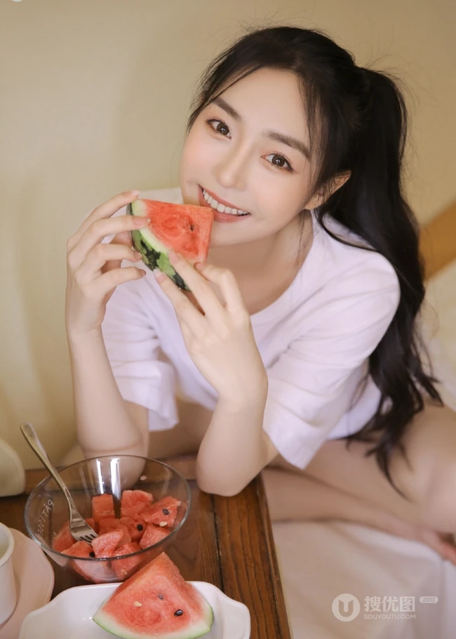 带酒窝的长发线条感少女居家清凉吃西瓜写真图片