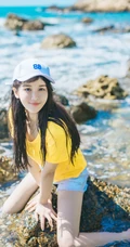 高颜值少女海礁石中戏水，黄衣短裤清新靓丽