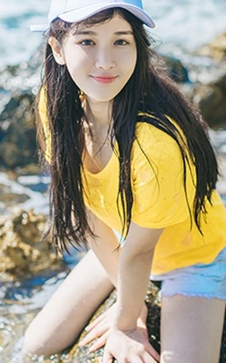 高颜值少女海礁石中戏水，黄衣短裤清新靓丽