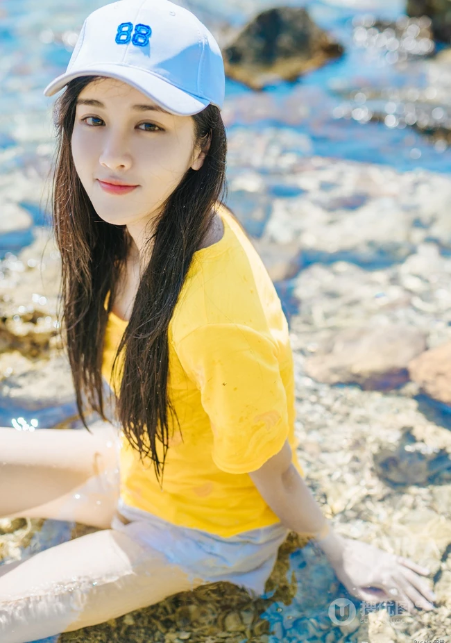 高颜值少女海礁石中戏水，黄衣短裤清新靓丽