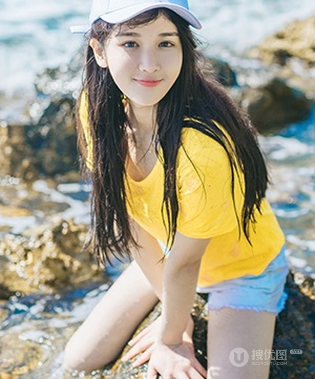 高颜值少女海礁石中戏水，黄衣短裤清新靓丽