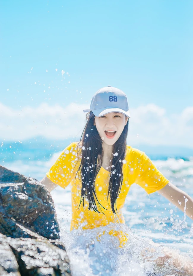 高颜值少女海礁石中戏水，黄衣短裤清新靓丽