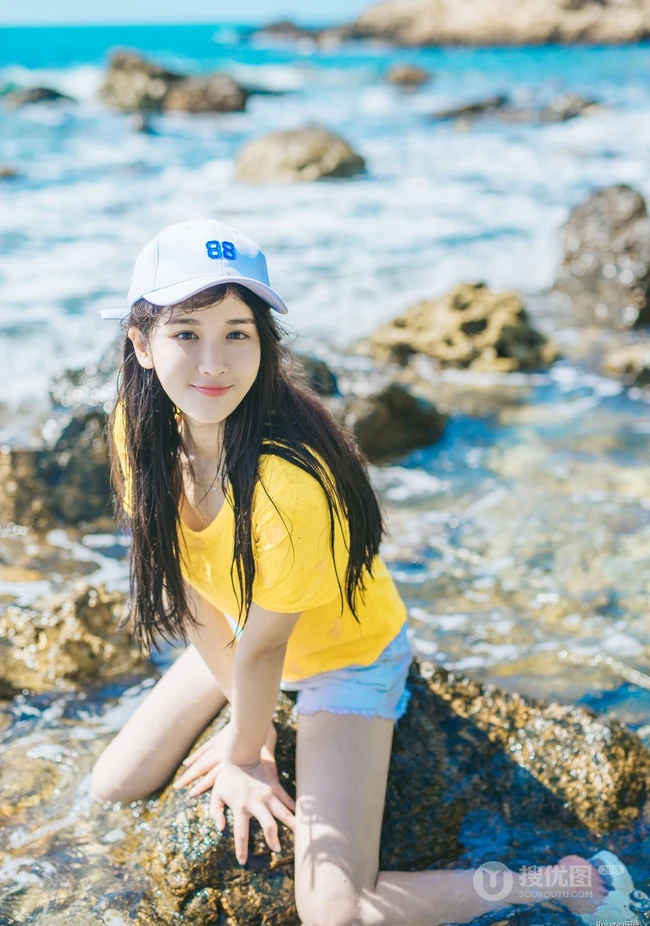 高颜值少女海礁石中戏水，黄衣短裤清新靓丽