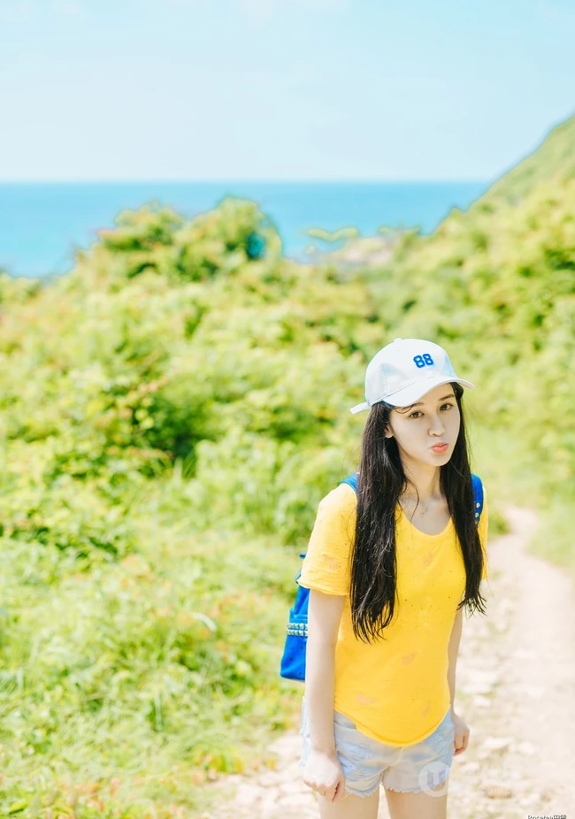 高颜值少女海礁石中戏水，黄衣短裤清新靓丽
