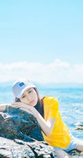 高颜值少女海礁石中戏水，黄衣短裤清新靓丽