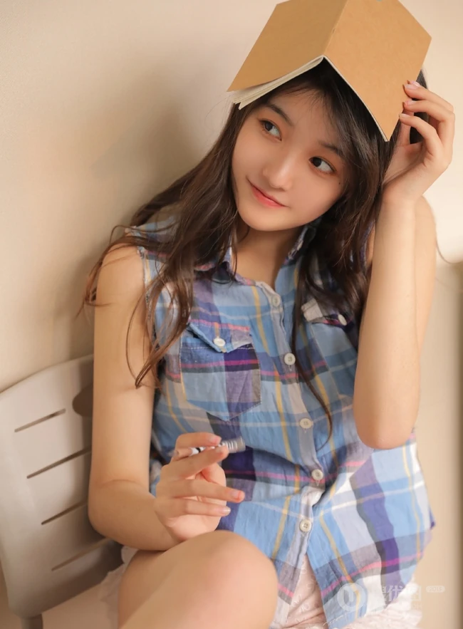 古灵精怪的女孩，穿着清爽的格子衬衫，边学习别拍写真