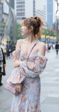 街上玩手机的肩带连衣裙白皙女生气质街拍照片