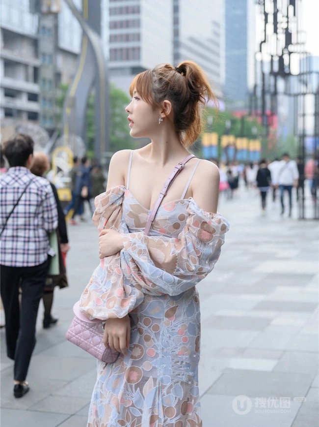 街上玩手机的肩带连衣裙白皙女生气质街拍照片
