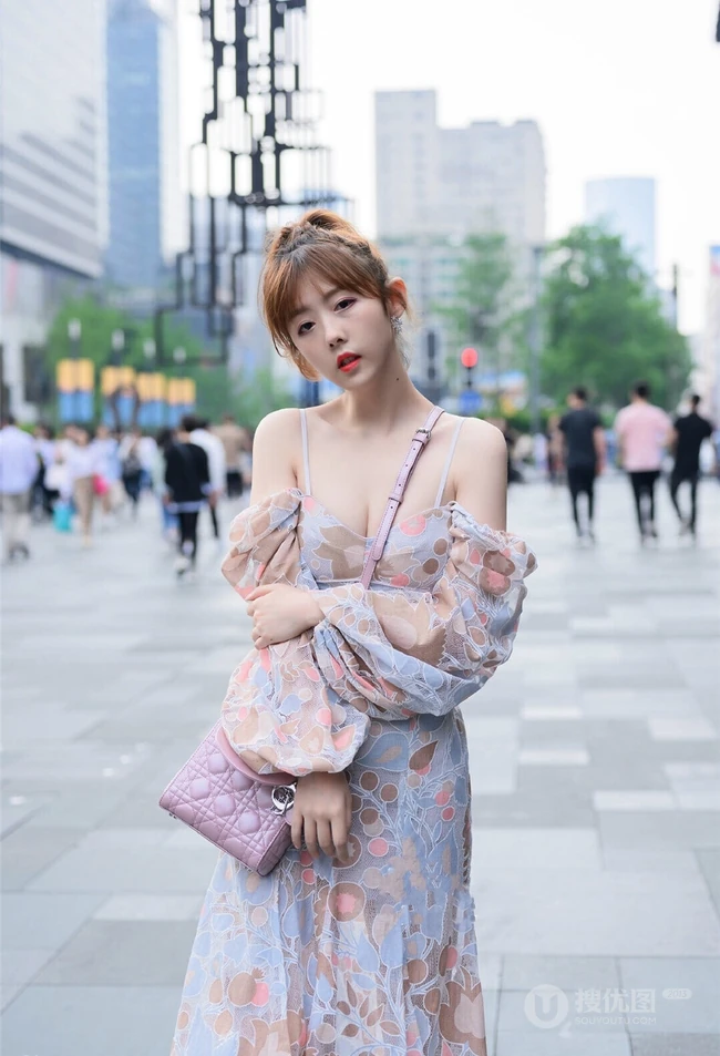 街上玩手机的肩带连衣裙白皙女生气质街拍照片
