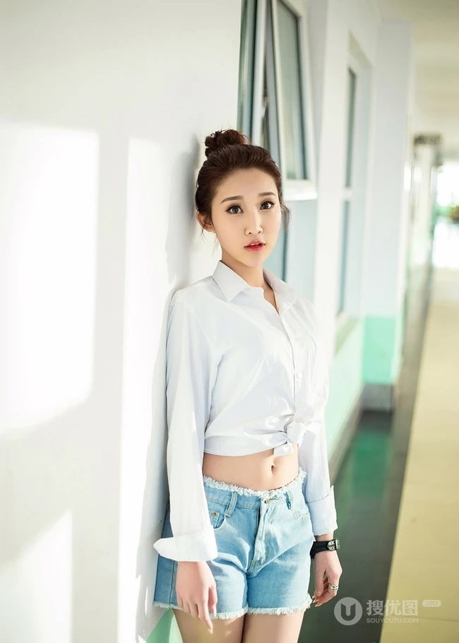 气质可爱衬衫牛仔短裤女生于湘霖走廊一侧玩足球写真
