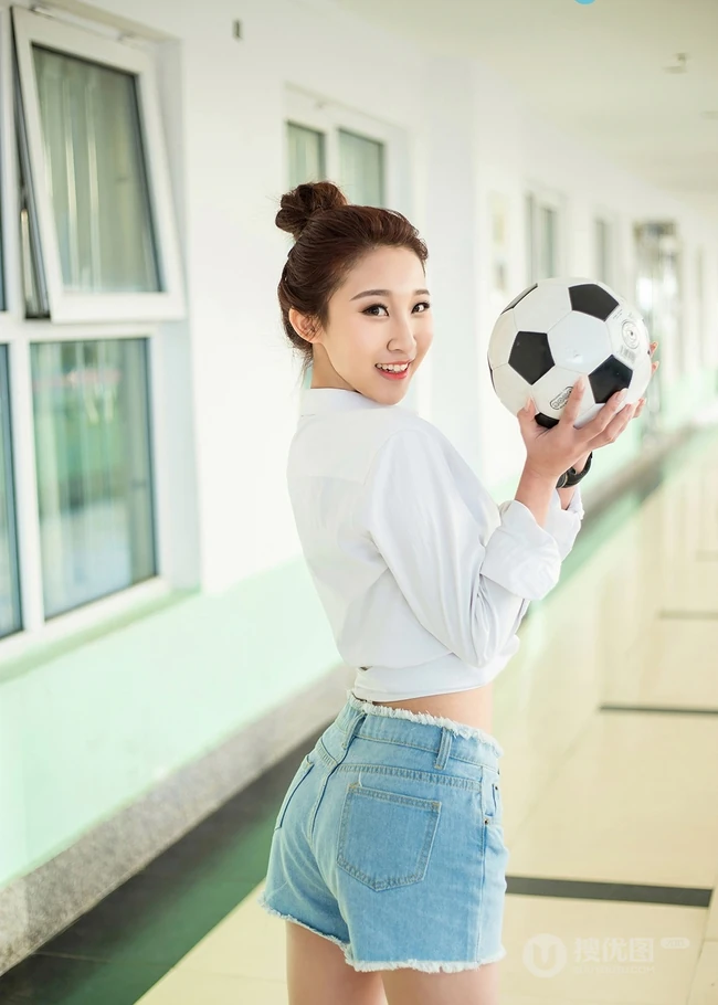 气质可爱衬衫牛仔短裤女生于湘霖走廊一侧玩足球写真