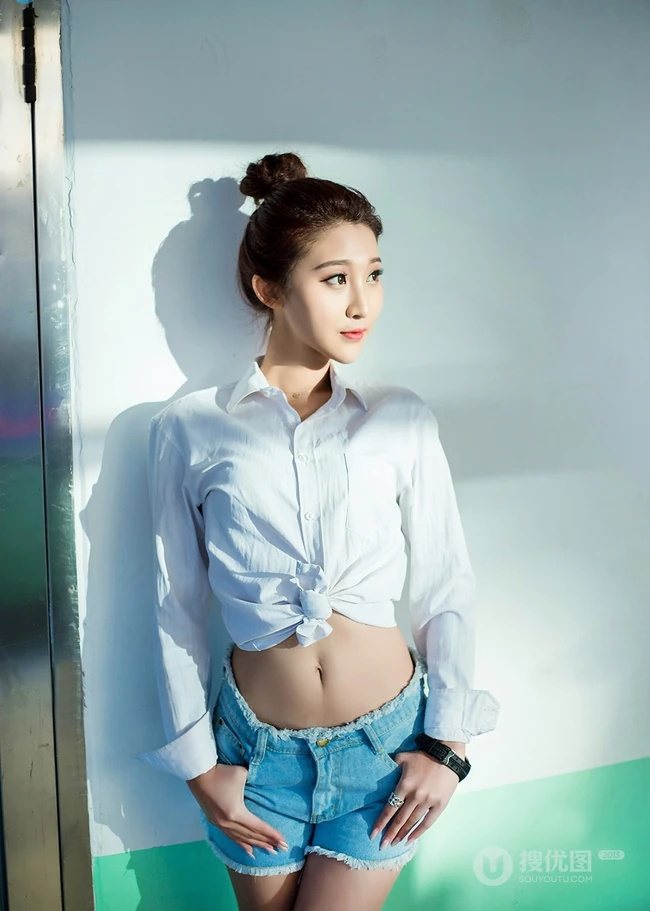 气质可爱衬衫牛仔短裤女生于湘霖走廊一侧玩足球写真