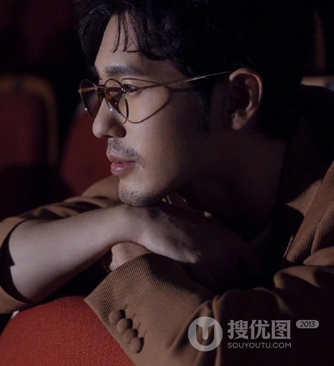 白宇着棕色西装在剧场座位上深沉专注写真图片