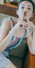 李一桐丸子头发型俏皮嘟嘴写真大图，肩带短款装配长裙浅粉可爱