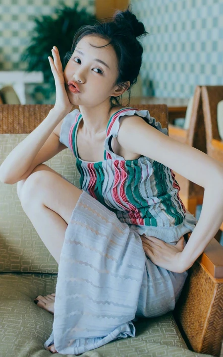 李一桐丸子头发型俏皮嘟嘴写真大图，肩带短款装配长裙浅粉可爱