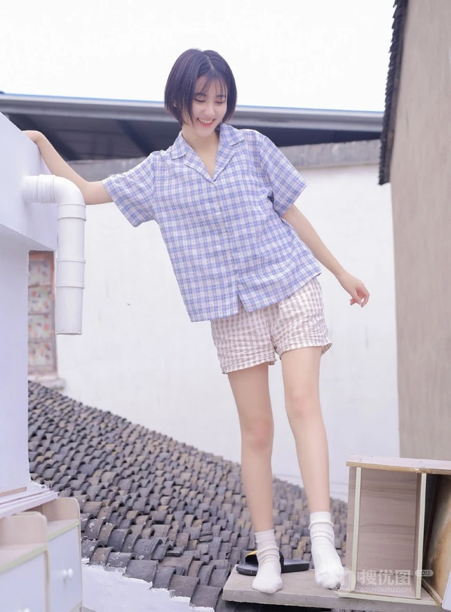 短发短衫短裤少女瓦片房楼顶露白皙线条感笑容写真图片