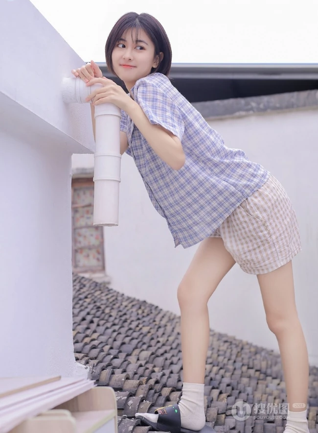 短发短衫短裤少女瓦片房楼顶露白皙线条感笑容写真图片