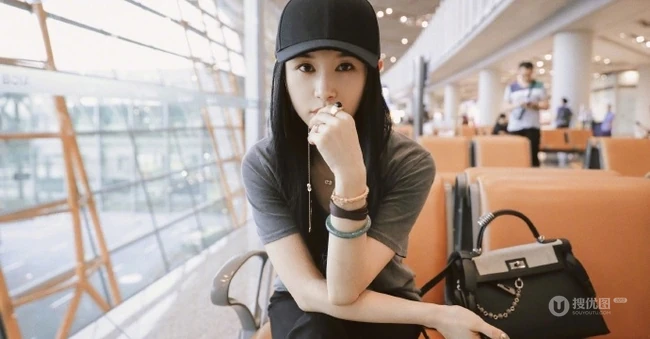 王子文微博晒灰衣黑帽个性美图，候机厅座位上自娱自乐