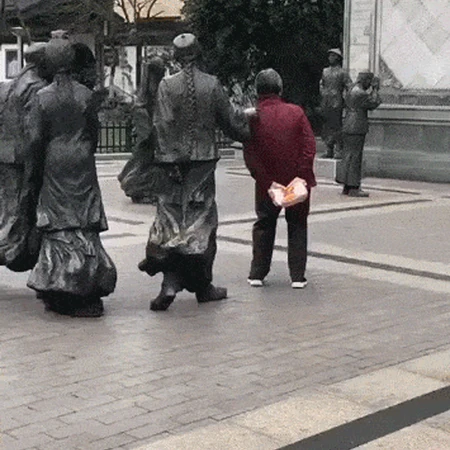 在雕像旁边蹭痒的大妈