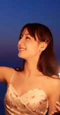 迪丽热巴着肩带裙夜晚海边唯美写真，手拿烟花笑容灿烂