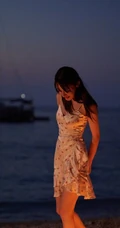 迪丽热巴着肩带裙夜晚海边唯美写真，手拿烟花笑容灿烂