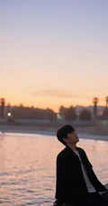 朱一龙黑衣牛仔裤海边悠闲帅气侧颜写真图片