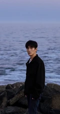 朱一龙黑衣牛仔裤海边悠闲帅气侧颜写真图片
