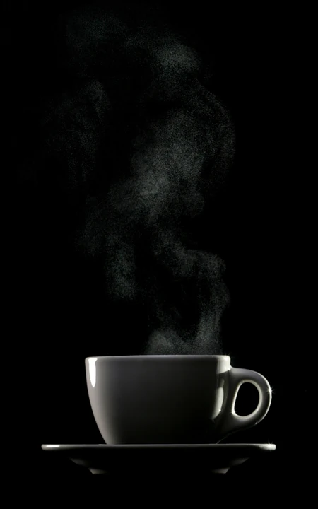 一杯热茶，一点温暖，纯黑色背景中的冒气热茶手机壁纸