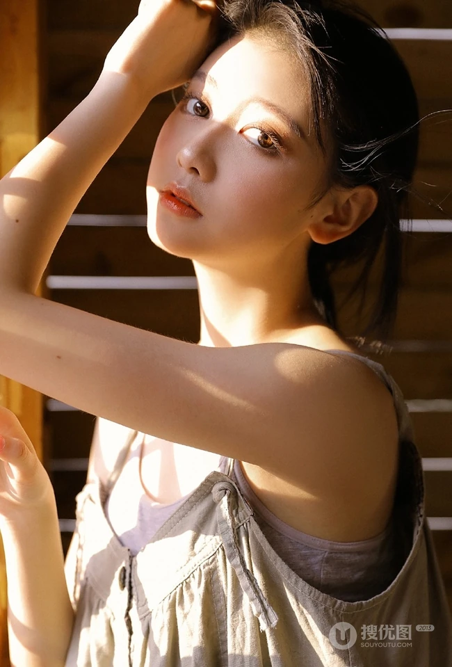 长发大眼线条感小姐姐灰色肩带裙坐藤椅上气质室内写真