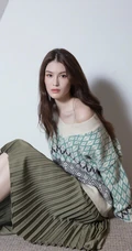 何穗席地而坐居家写真图片，针织衫搭绿裙侧漏香肩