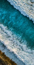 迎着海风踏浪，高清海水拍打沙滩的航拍手机壁纸