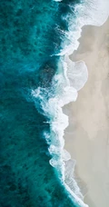 迎着海风踏浪，高清海水拍打沙滩的航拍手机壁纸